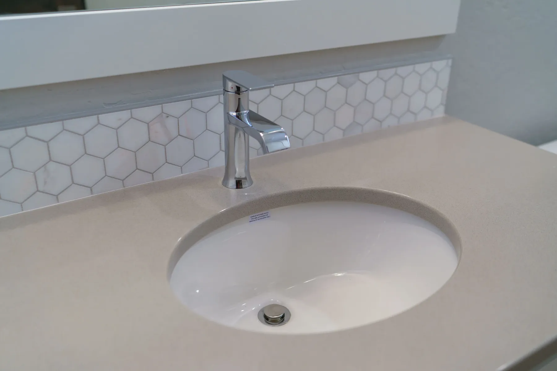 Hex mosaic backsplash: Undermount basin set in a clean quartz top.